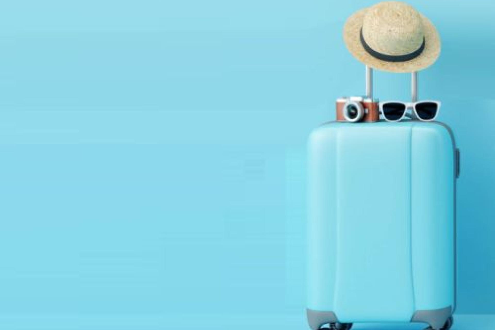 Koffer met zonnehoed en camera en zonnebril