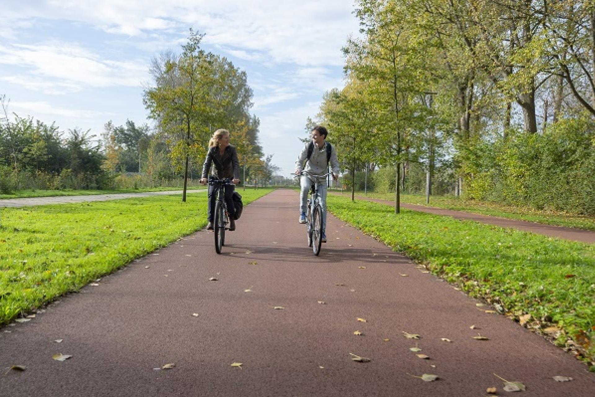 twee fietsers naast elkaar op een breed fietspad op de Pontweg in Velsen