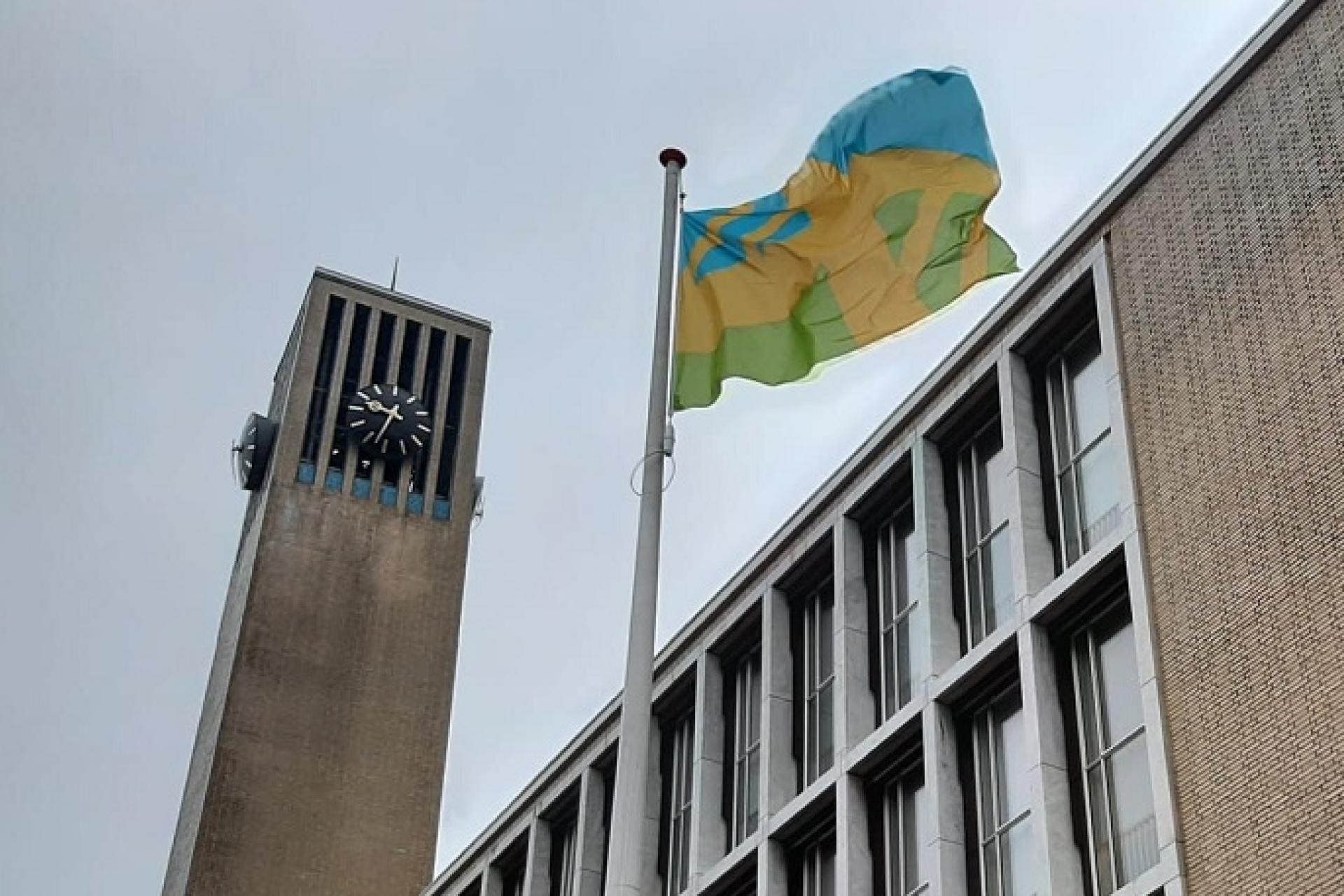 mensenrechtenvlag wappert voor het gemeentehuis in IJmuiden