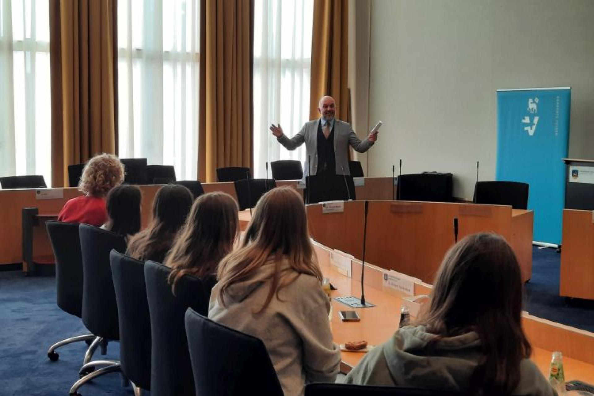 Leerlingen uit Bergisch Gladbach luisteren in de raadzaal naar een uitleg door Jeroen Verwoort